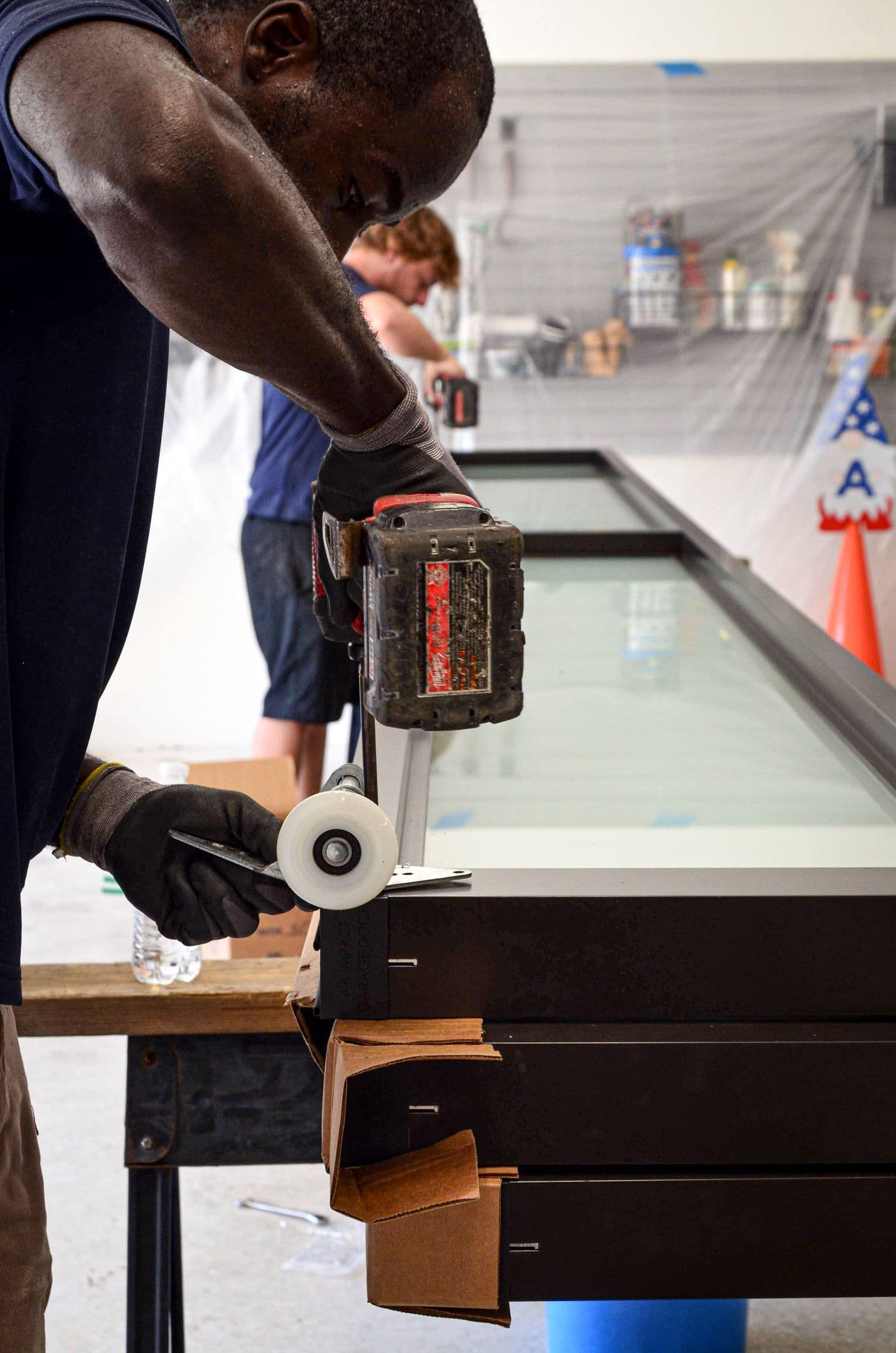 Team Member Drilling Garage Door Roller